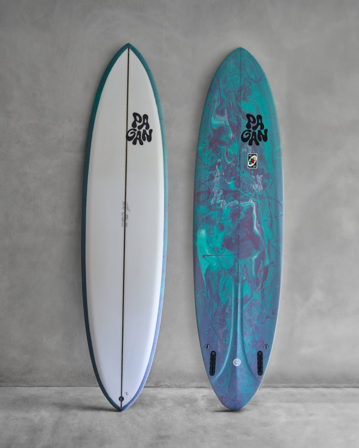 Two Pagan boards against a grey wall